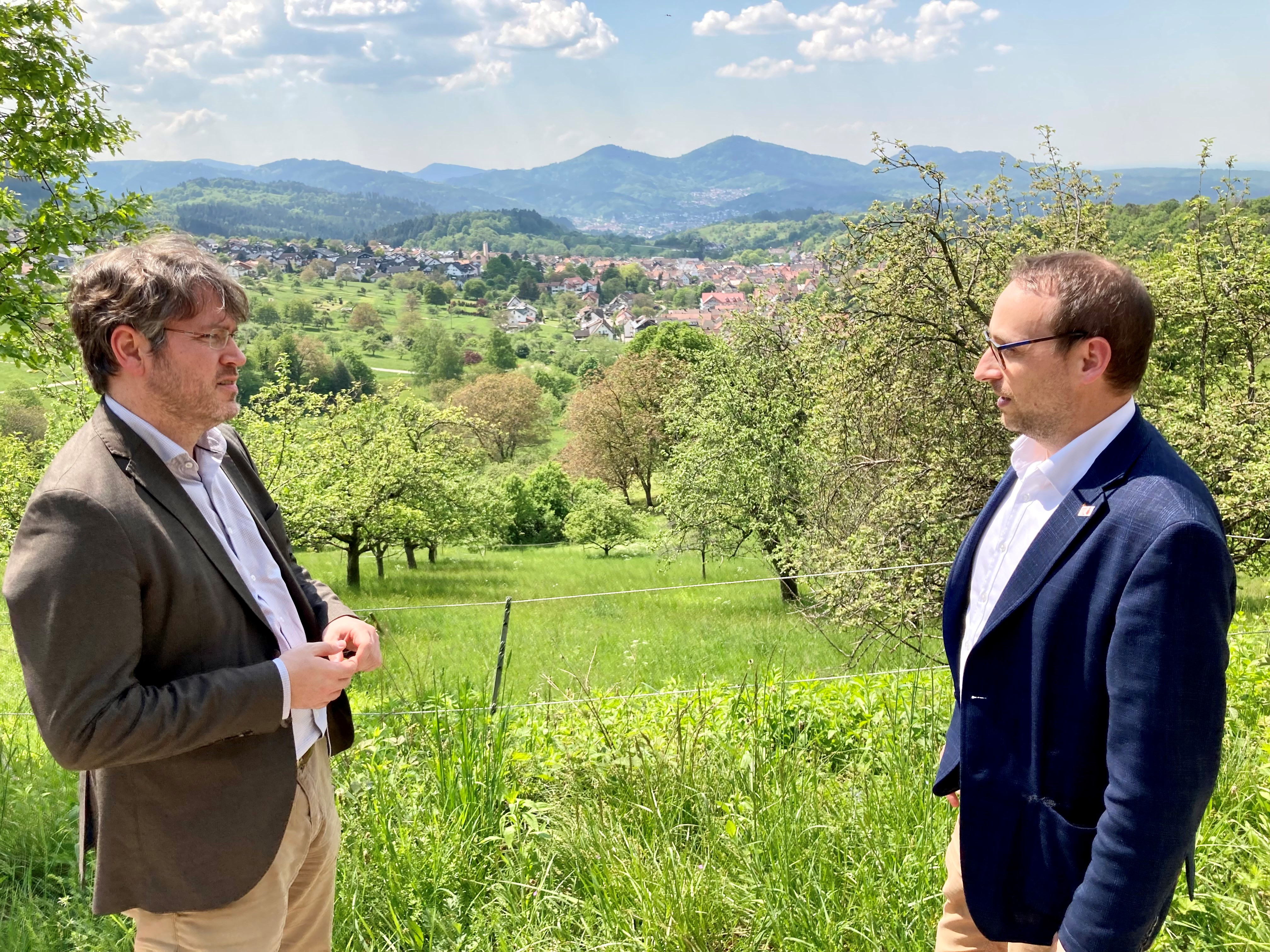 Auf diesem Bild sind der Landrat Dr. Christian Dusch (links) und Bürgermeister Markus Burger im Gespräch vor dem Panorama von Loffenau zu sehen.